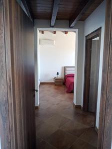 MontevagoCASA RURALE IMPASTATO的走廊上设有一张床和一扇门的房间