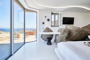 阿诺梅拉Teal Rock Mykonos的一间卧室配有一张床,享有海景