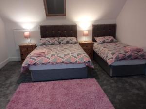 穆林加尔Greenway Guesthouse的一间卧室配有两张床和两盏台灯。