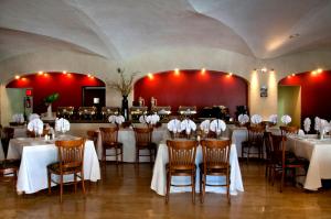 莱昂瑞奥米娜斯薄路瑞木酒店的一间设有白色桌椅和红色墙壁的餐厅
