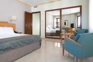 科尔多瓦欧洲之星迈蒙尼德酒店的一间卧室配有一张床、一张沙发和一把椅子