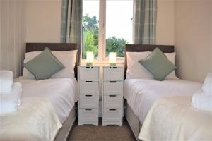 MantonOsprey Cottage, Manton in Rutland的带窗户的客房内设有两张单人床。