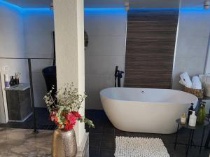 埃拉特daniela的浴室设有白色浴缸和花瓶