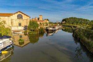 科隆比耶尔Maison de vacances proche du canal du midi et de la mer的一条河,在水中划船,靠近一座建筑