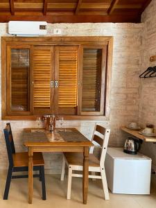 蒙特韦尔迪Refúgio Physis Suítes的厨房里配有一张木桌和椅子