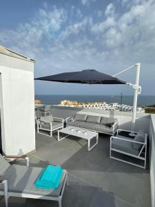 福恩吉罗拉Luxury Penthouse Pedro - The View Fuengirola的屋顶上带遮阳伞和沙发的庭院