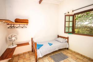 帕拉蒂EcoLodge Paraty的一间卧室设有一张床、一个窗口和风扇