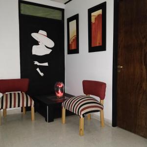 圣萨尔瓦多德朱Rosa Ramona Rooms的一间设有两把椅子和一张桌子的房间,一张图片