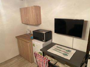 特罗亚诺维采Chata v Beskydech Trojanovice的小房间设有桌子、电视和小冰箱