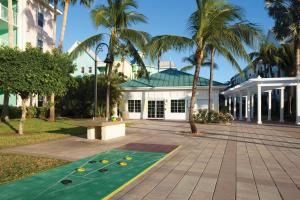 拿骚亚特兰蒂斯港湾度假酒店的一座棕榈树和果岭的建筑