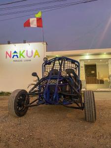 帕拉卡斯Nakua Paracas Lodge的停在大楼前的蓝色四轮车