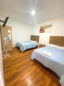 帕拉卡斯Nakua Paracas Lodge的一间设有两张床和相机的房间