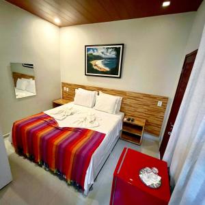 费尔南多 - 迪诺罗尼亚Noronha Good Vibes Hostel的一间卧室配有一张大床和色彩缤纷的毯子