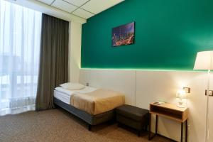 鄂木斯克Urban Hotel的酒店客房,设有床铺和绿色的墙壁