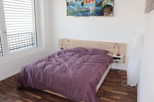 洛桑Beautiful Loft In The Center Of Lausanne的一间卧室设有紫色的床和窗户