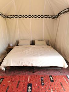 El GoueraBivouac Erg Chegaga Nomademoi的帐篷内一间卧室,配有一张床