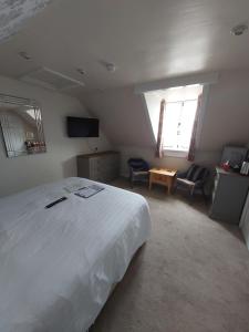 韦茅斯雷德克利夫酒店的一间带白色大床的卧室和一间客厅