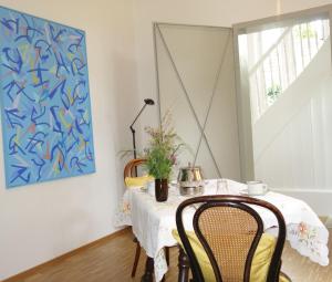 巴登-巴登Bed & Breakfast Grünes Gold am Leisberg的用餐室配有桌椅和绘画作品