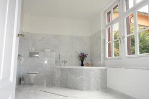巴登-巴登Bed & Breakfast Grünes Gold am Leisberg的白色的浴室设有浴缸和卫生间。