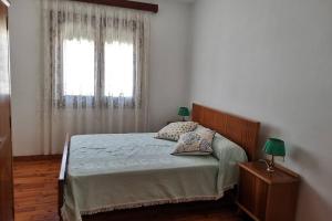 安索Casa Tía María的一间卧室配有一张带两盏灯的床和一扇窗户。