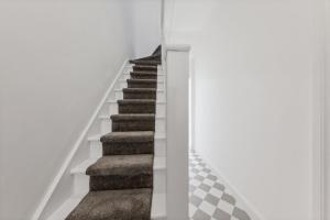 伦敦Stunning house的白色墙壁和地毯的房屋内的楼梯