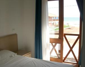 圣玛丽亚Two Bedroom Apartment with Sea View Fogo Residence的一间卧室配有一张床,享有海滩美景