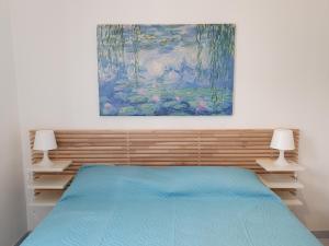 诺托玛丽娜Appartamento Ionios的卧室配有一张床,墙上挂有绘画作品
