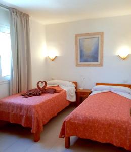 卡门港Apartamentos Tamarindos的酒店客房设有两张床和窗户。