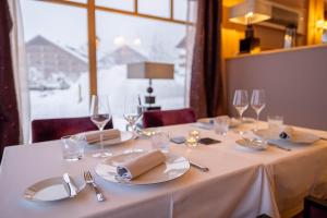 威拉尔-苏-罗伦瑞欧亚普木屋温泉酒店的一张桌子,上面有白色的桌布,盘子和眼镜