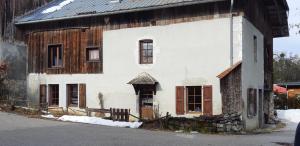 莫里永Chalet montagne 11 p Grand Massif 100 m télécabine的一座古老的白色房子,配有木头