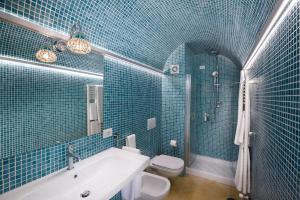 圣安吉洛多恩卡米洛别墅旅馆的蓝色瓷砖浴室设有浴缸和卫生间