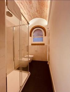 帕尔马Palazzo Borgocolonne Apartments的一间带玻璃淋浴和水槽的浴室