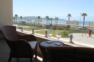 科金博Departamento Av del Mar Coquimbo Disegni 03的一张桌子和两杯酒,享有海滩美景