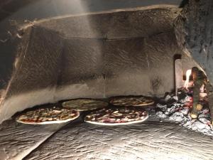 百瑞思西亚诺Albergo Ristorante Monte Selva的三个比萨饼正在烤箱里煮熟