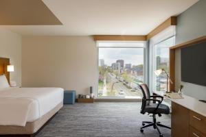 罗切斯特EVEN Hotels Rochester - Mayo Clinic Area, an IHG Hotel的配有一张床、一张书桌和一扇窗户的酒店客房