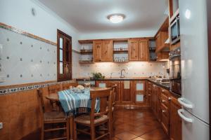 休达德亚Menurka-Santa Clara的厨房配有木制橱柜和桌椅