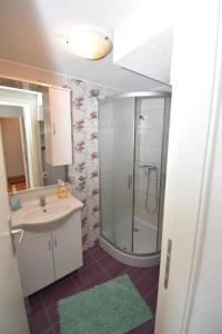 希贝尼克Apartmani Mihaela的带淋浴、盥洗盆和镜子的浴室