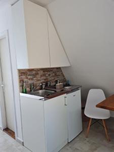 维尔蒂尼克Apartmani Radaković的厨房配有白色橱柜和水槽