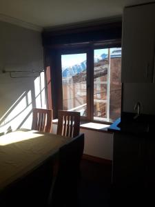 El Colorado埃尔科罗拉多海皮特阿马尔公寓的客房设有桌子、两把椅子和窗户。