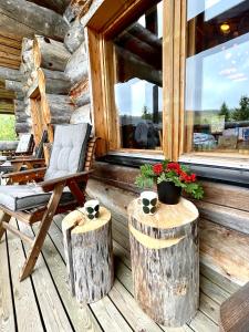 鲁卡Ruka View at the Slopes Ski in, Family & Bike Park, National Park, hike trails - Lapland Villas的门廊上的椅子,带木柴和窗户