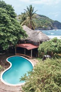 埃尔蒙特Esencia Nativa的一个带游泳池和茅草屋顶的度假胜地