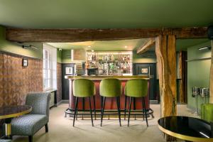 亨利昂泰晤士The Relais Henley的一间酒吧,在一间房间里设有绿色的酒吧凳子