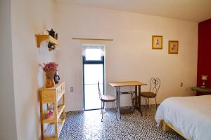 库埃纳瓦卡Hermosa Suite Privada en Casa Holística的卧室配有一张床和一张桌子及椅子