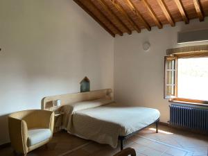 圣吉米纳诺Bed & Breakfast Casale Gregoriano and Apartaments的卧室配有床、椅子和窗户。