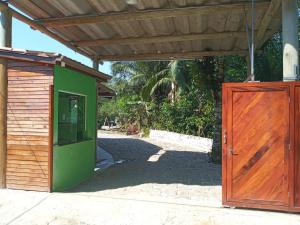 乌巴图巴Suites Brejauva的绿色的木制建筑,设有木门