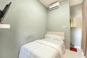 Talang KelapaPelangi Guest House Palembang RedPartner的白色卧室配有白色床单