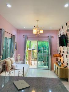 Ban MuangIris Homestay的粉红色的房间,设有床和滑动玻璃门