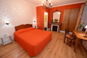 沙尼Hôtel De La Ferté的一间卧室配有一张橙色的床和一张书桌
