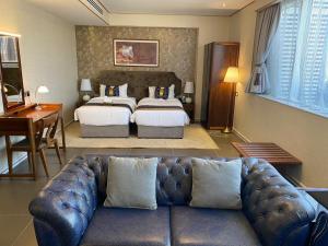 胡富夫Al Ahsa Grand Hotel的客厅配有沙发和1张床