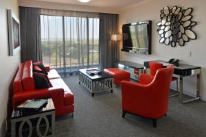 达尔文达尔文帕默斯顿莱吉斯酒店的客厅配有红色家具和大窗户